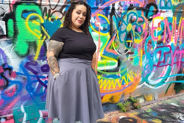 Leslie DeJesus poses for a photo in Graffiti Alley in Baltimore.