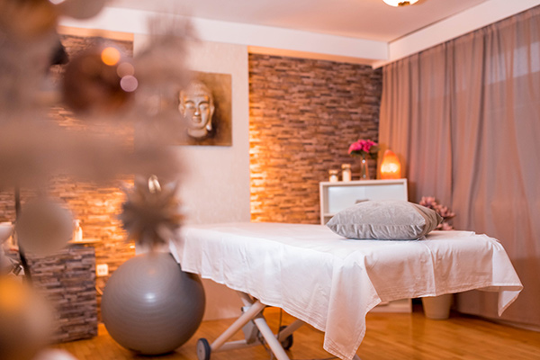 Tranquil and inviting spa setting with soft lighting and a massage table