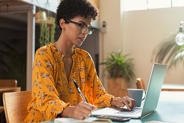 A young woman in front of a laptop taking an online education course