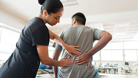 Image of a massage therapist working on a client's lower back.