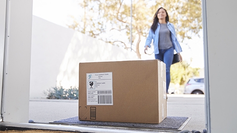 Image of a person walking towards a delivered package.