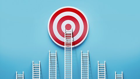 Ladders leaned up against a blue wall, with the tallest ladder reaching the center of a target